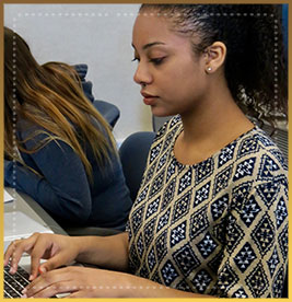 Female student types on computer keyboard